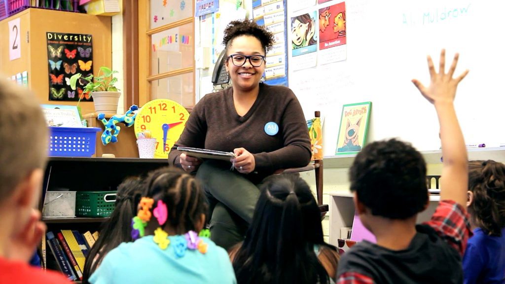 Ali Muldrow reads to young students at a "Read Your Heart Out" event.