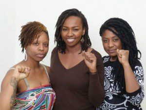 (L-r) Patrisse Cullors, Opal Tometi, and Alicia Garza hold up their fists in unison.