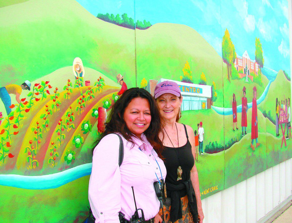 Sharon Kilfoy (right), with Former Centro Hispano Board Board President Gloria Reyes, in front of one of her many Centro Hispano murals that she has painted with Madison-area young people.