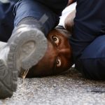 A man protesting the shooting death of Alton Sterling is detained by law enforcement near the headquarters of the Baton Rouge Police Department in Baton Rouge, Louisiana
