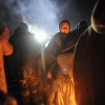 A protester gets warm by a fire during a protest against plans to pass the Dakota Access pipeline near the Standing Rock Indian Reservation, near Cannon Ball, North Dakota, U.S.