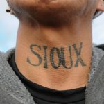 A man from the Lakota Sioux tribe with a Native American tattoo on his neck poses for a photograph during a protest against plans to pass the Dakota Access pipeline near the Standing Rock Indian Reservation, near Cannon Ball, North Dakota