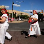 Members of an indigenous peoples support group called RAICES perform a blessing ceremony as protesters gather outside before Trump holds a rally with supporters in Albuquerque